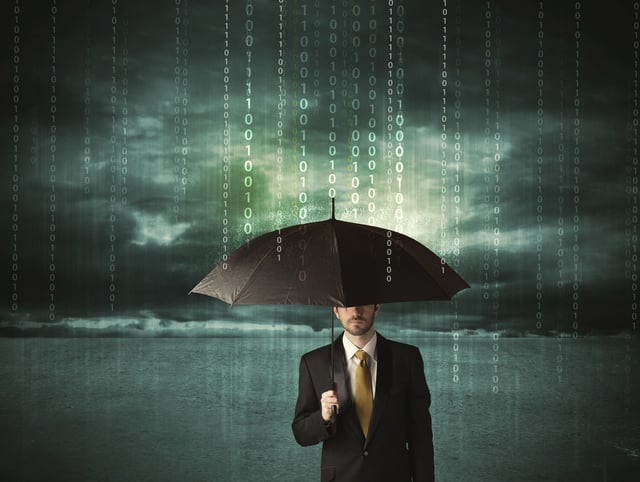 Business man standing with umbrella data protection concept on background.jpeg